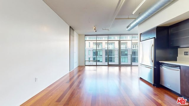 kitchen with dark wood-type flooring, a wall of windows, and appliances with stainless steel finishes