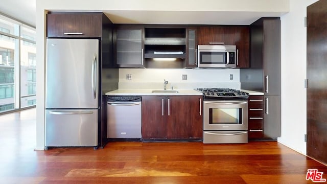 kitchen featuring floor to ceiling windows, sink, stainless steel appliances, and a healthy amount of sunlight