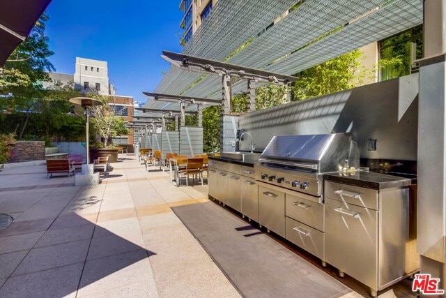 view of patio with area for grilling and sink