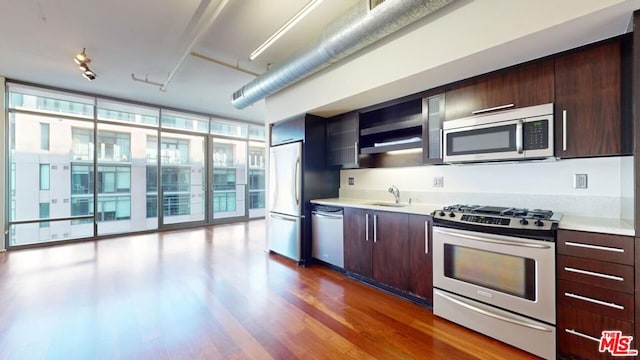 kitchen with sink, appliances with stainless steel finishes, a wealth of natural light, and floor to ceiling windows