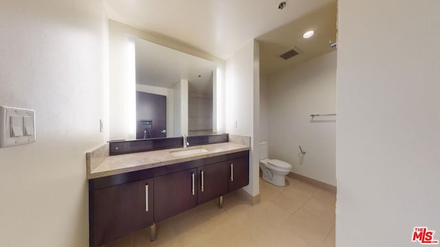 bathroom featuring toilet, vanity, and tile patterned floors