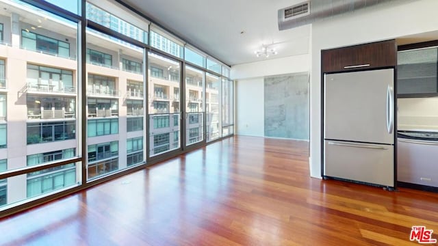 interior space with a chandelier, a wall of windows, and hardwood / wood-style flooring