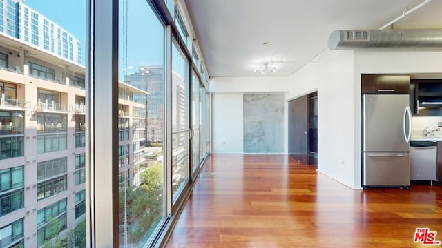 hallway featuring a wealth of natural light, hardwood / wood-style flooring, expansive windows, and sink