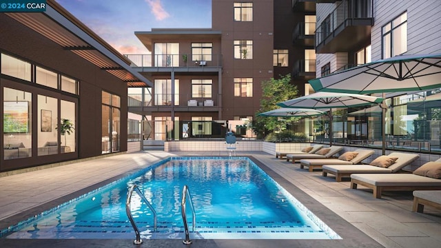 pool at dusk featuring a patio area