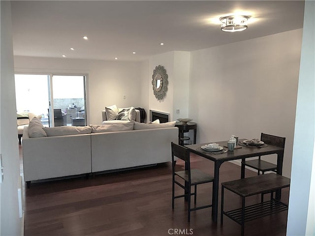 dining area featuring recessed lighting, a fireplace, and dark wood-style flooring