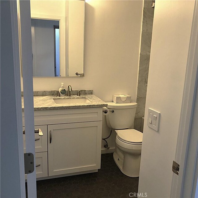 bathroom featuring toilet, vanity, and tile patterned flooring