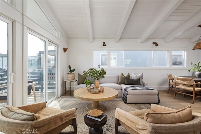 sunroom / solarium featuring a healthy amount of sunlight and beamed ceiling