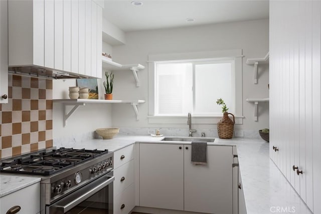 kitchen featuring sink, white cabinets, ventilation hood, and high end stove