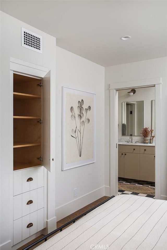 unfurnished bedroom featuring ensuite bath, sink, and light hardwood / wood-style floors