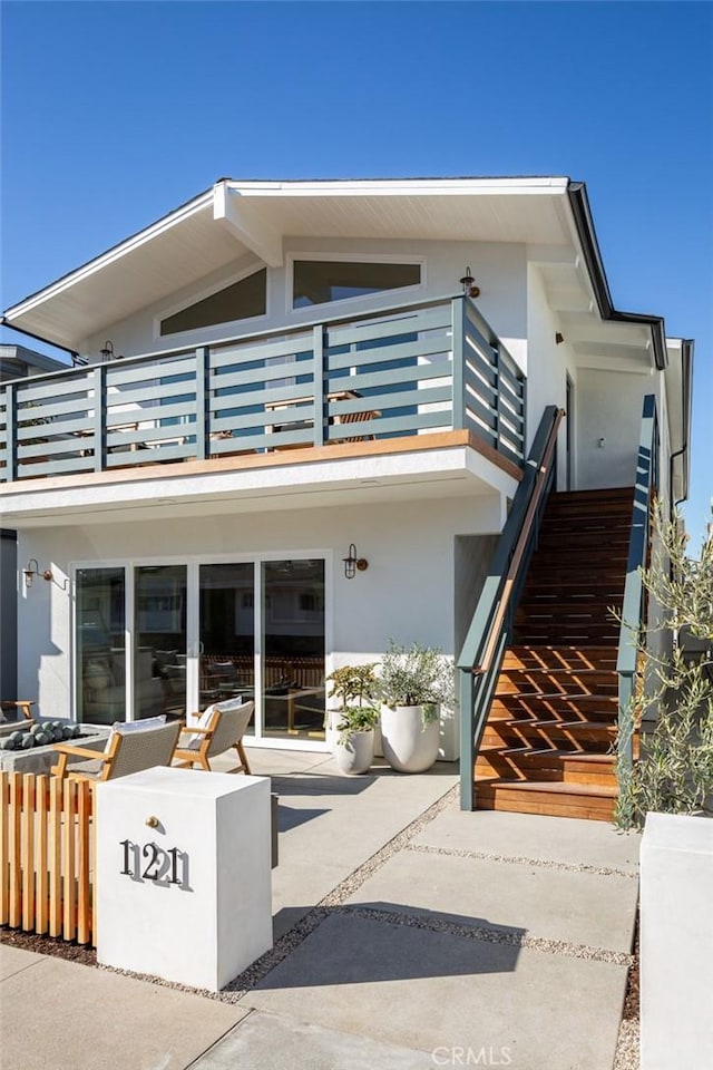 view of front facade with a patio area and a balcony