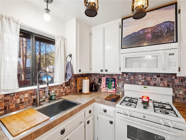 kitchen featuring white cabinetry, sink, white appliances, and tasteful backsplash