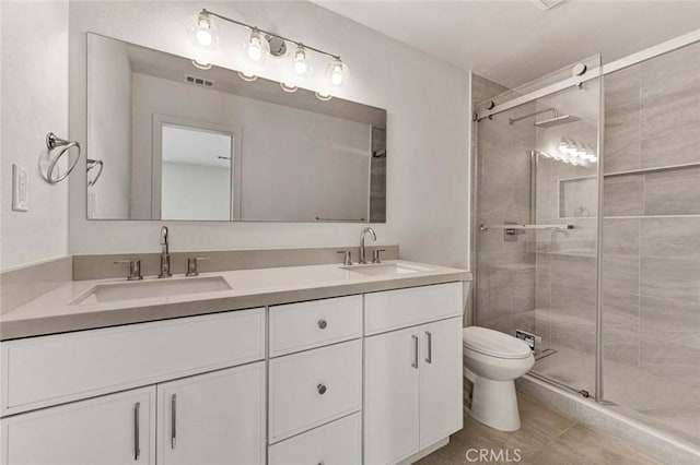 bathroom with walk in shower, vanity, toilet, and tile patterned flooring