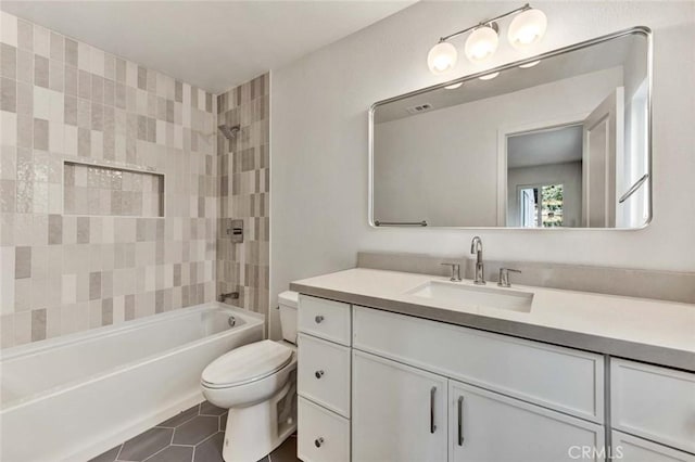 full bathroom with tiled shower / bath combo, vanity, tile patterned flooring, and toilet