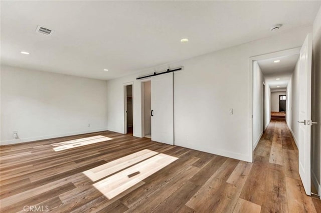 empty room featuring hardwood / wood-style flooring and a barn door