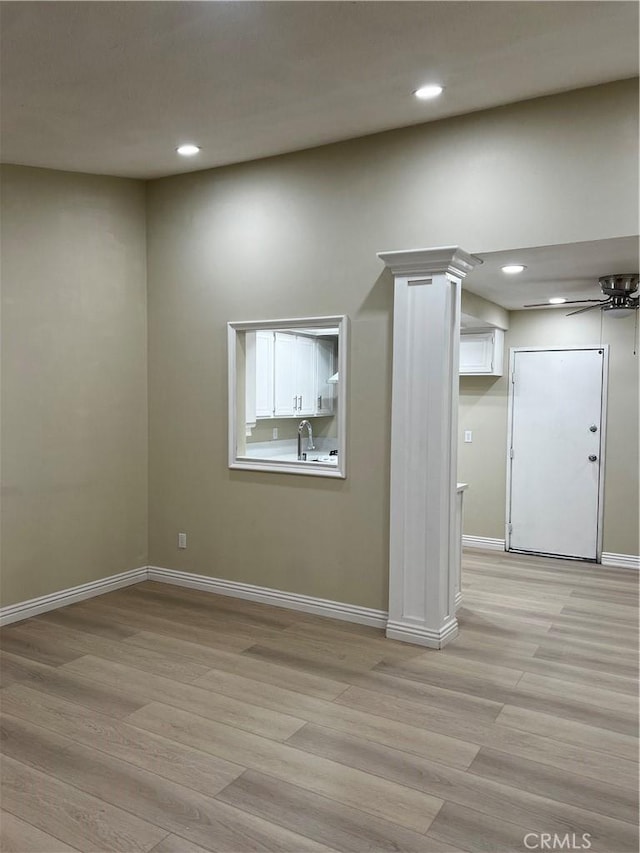 spare room with light wood-style flooring, baseboards, a sink, and recessed lighting