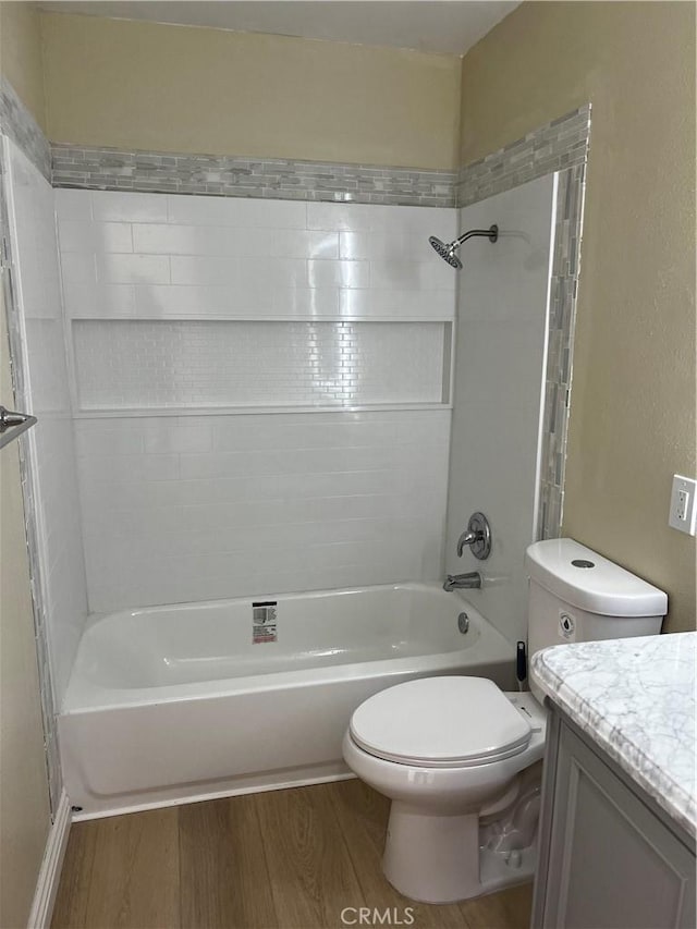 bathroom featuring toilet, washtub / shower combination, wood finished floors, and vanity