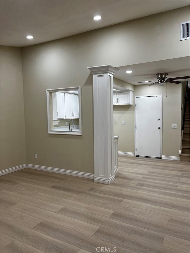 unfurnished room with stairway, light wood-type flooring, and visible vents