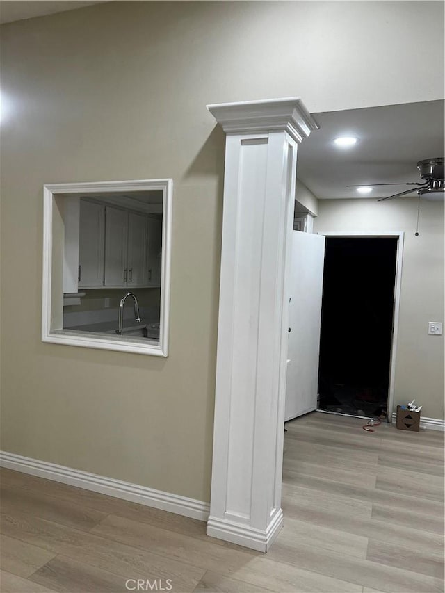 corridor with light wood-style floors, baseboards, and recessed lighting