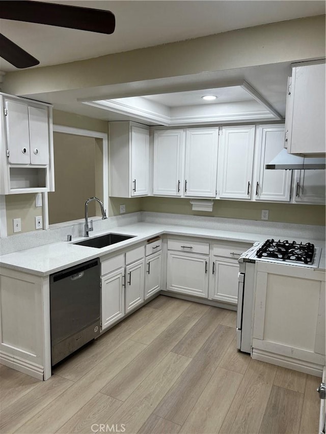 kitchen with a sink, white cabinetry, light countertops, stainless steel dishwasher, and light wood finished floors