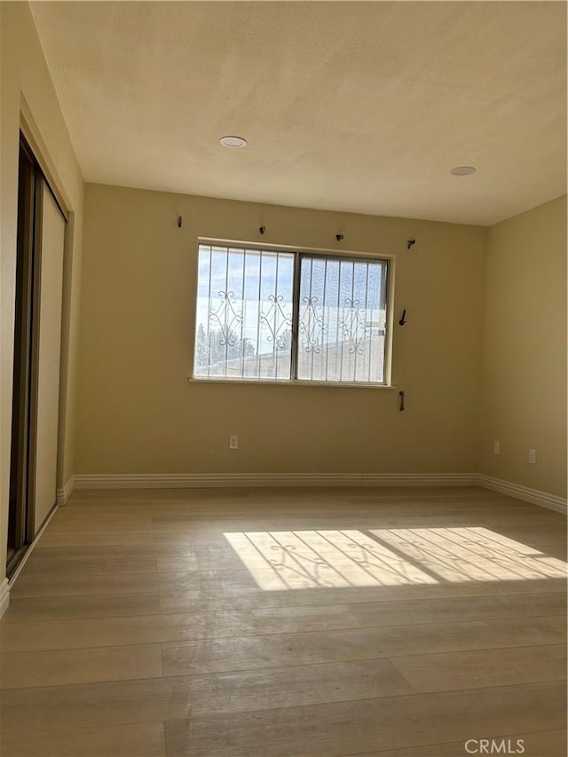 unfurnished room featuring light wood-style floors and baseboards