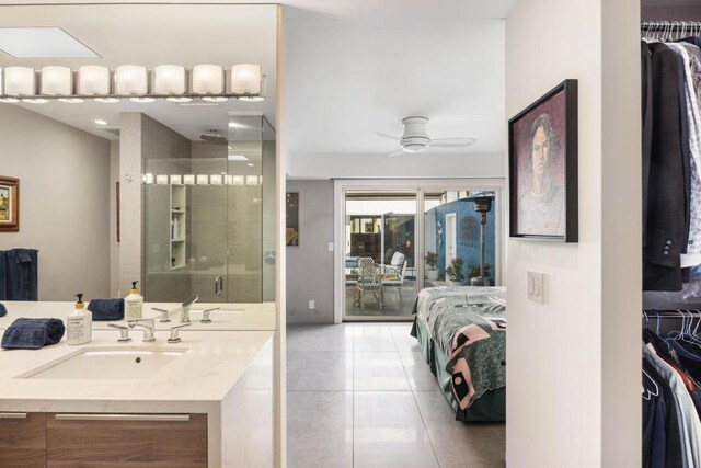 bathroom featuring ceiling fan, vanity, tile patterned flooring, and a shower with door