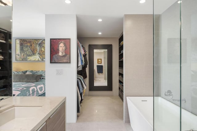 bathroom featuring plus walk in shower, vanity, and tile patterned flooring