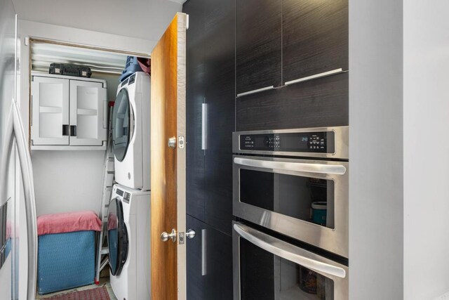 kitchen with stacked washer / drying machine and double oven