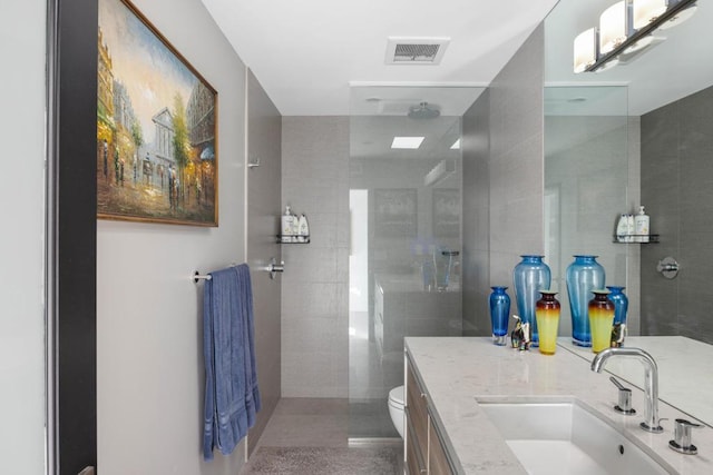 bathroom featuring walk in shower, vanity, and toilet