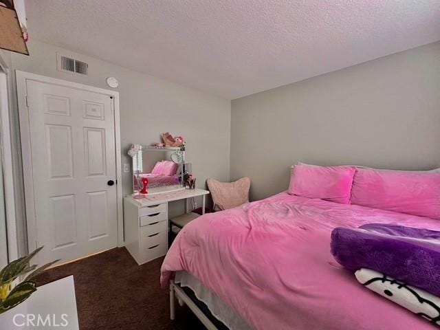 carpeted bedroom featuring a textured ceiling