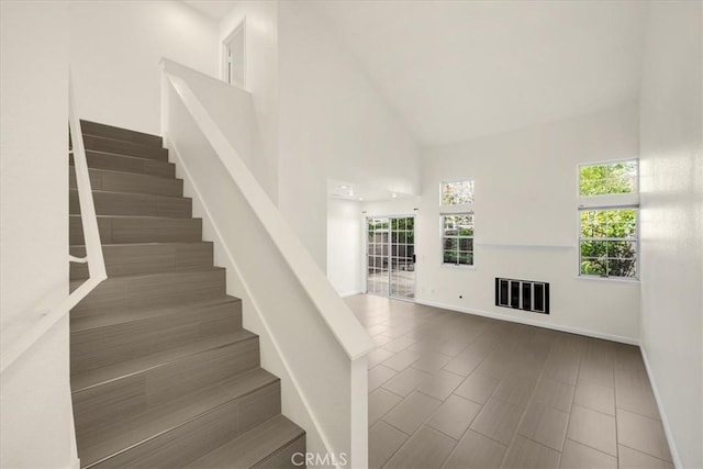 stairway featuring high vaulted ceiling