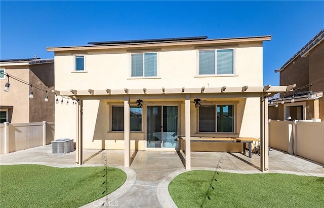 back of property featuring a patio, central AC, ceiling fan, a lawn, and solar panels