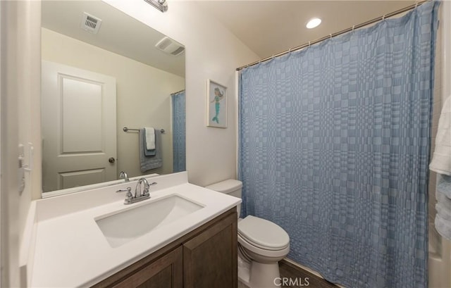 bathroom featuring toilet, vanity, and a shower with curtain