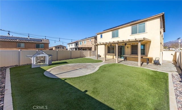 back of property with a pergola, a patio area, and a yard