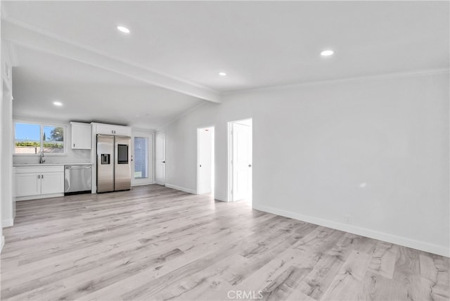 unfurnished living room with vaulted ceiling with beams, sink, crown molding, and light hardwood / wood-style floors