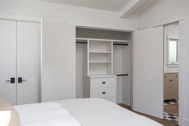 bedroom featuring beam ceiling and dark hardwood / wood-style flooring