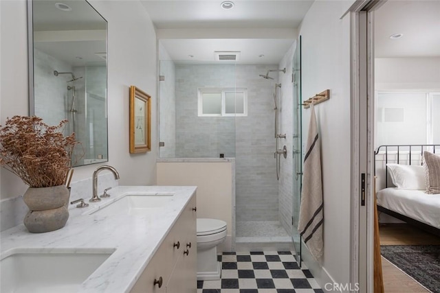 bathroom featuring tiled shower, vanity, and toilet