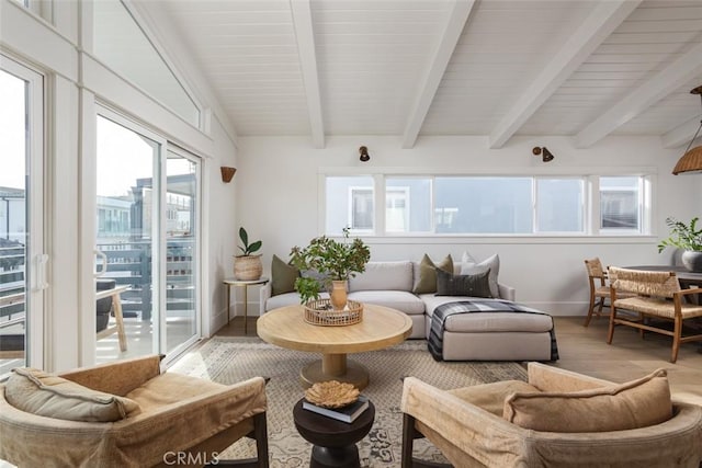 sunroom featuring a healthy amount of sunlight and beam ceiling