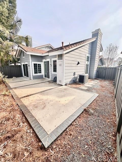 back of house with central air condition unit and a patio