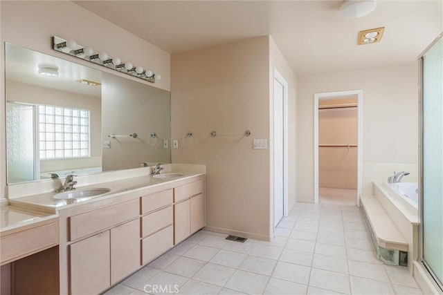 bathroom featuring a bathtub, vanity, and tile patterned flooring