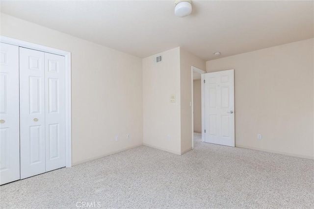 unfurnished bedroom featuring a closet and light colored carpet