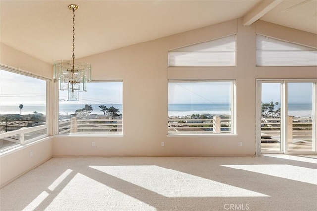 interior space featuring a water view, plenty of natural light, lofted ceiling with beams, and a notable chandelier