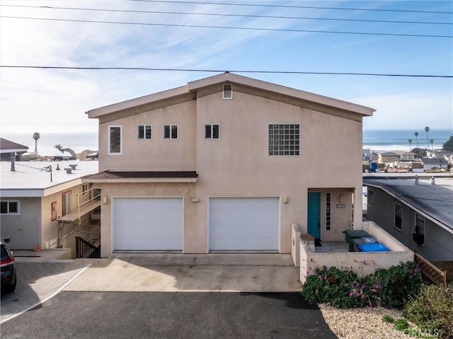 view of front facade with a water view and a garage