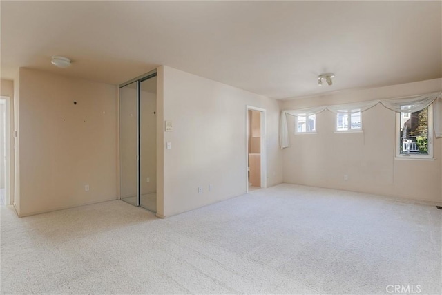 unfurnished room featuring light carpet