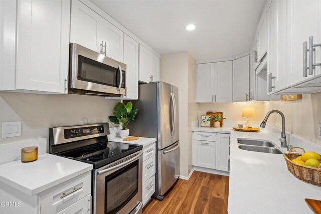 kitchen with light hardwood / wood-style floors, sink, white cabinets, and stainless steel appliances