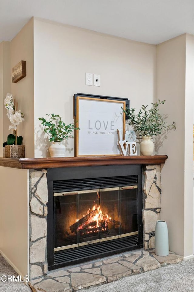 interior details featuring a fireplace and carpet