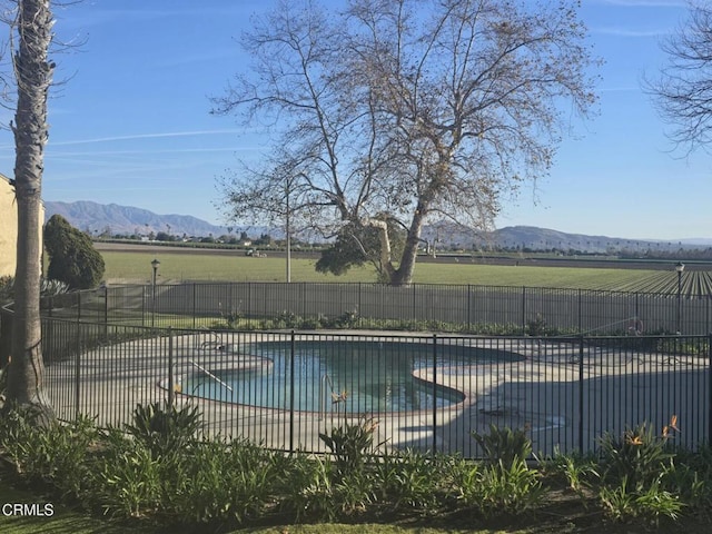 view of pool featuring a mountain view, a patio, and a rural view