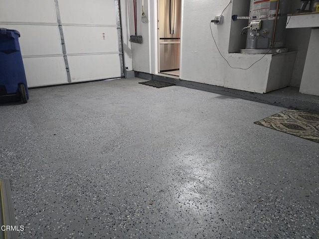 garage featuring stainless steel refrigerator and gas water heater