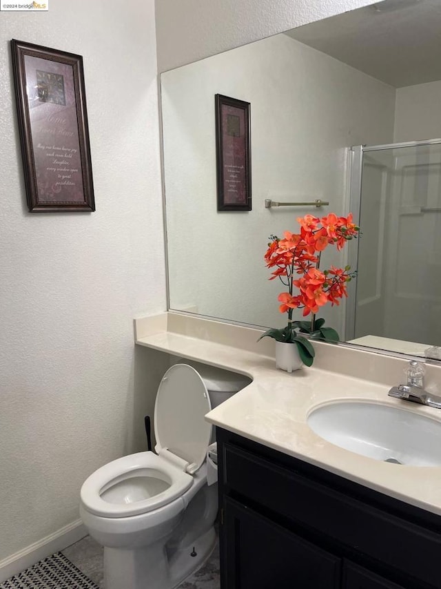 bathroom with toilet, vanity, tile patterned flooring, and a shower with door