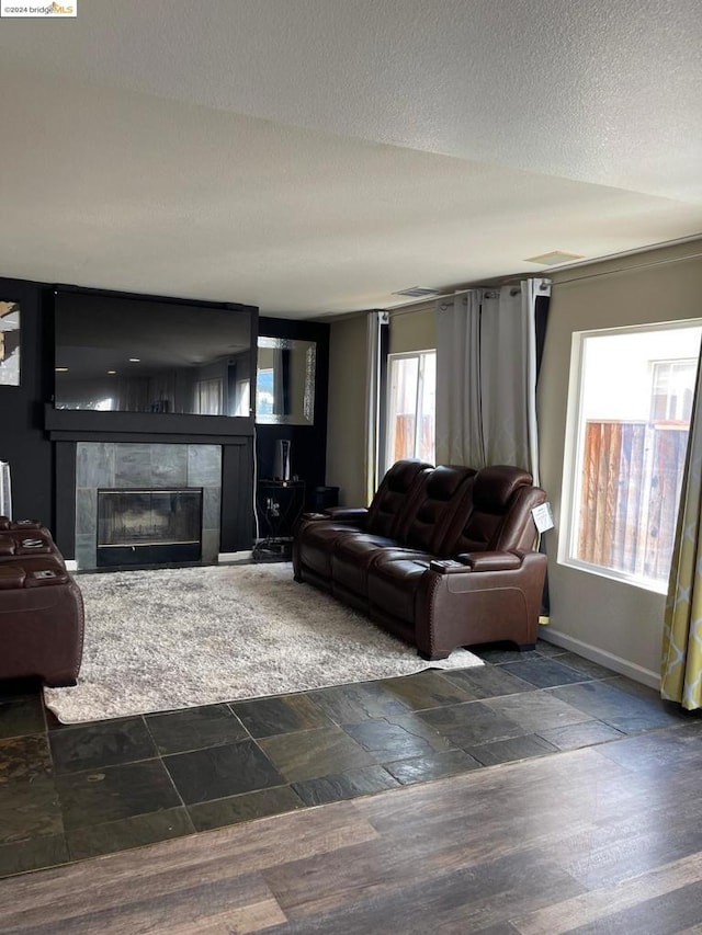 living room with a textured ceiling and a fireplace