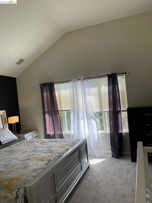 bedroom with light colored carpet and lofted ceiling